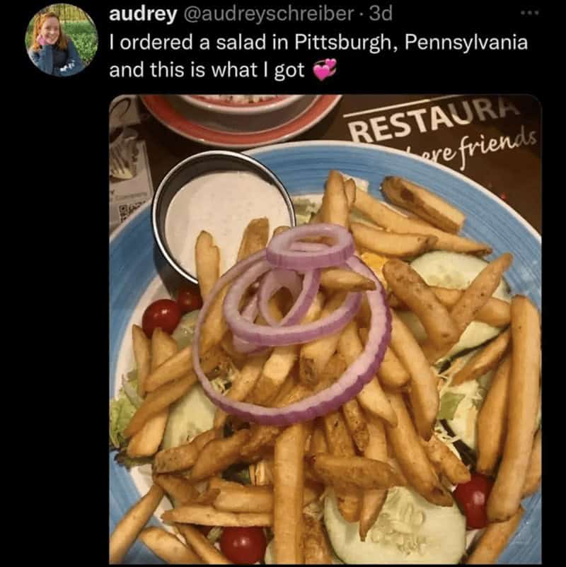 Pittsburgh-style salad topped with an overwhelming amount of French fries and onion rings serves as a viral caesar salad meme about regional food.