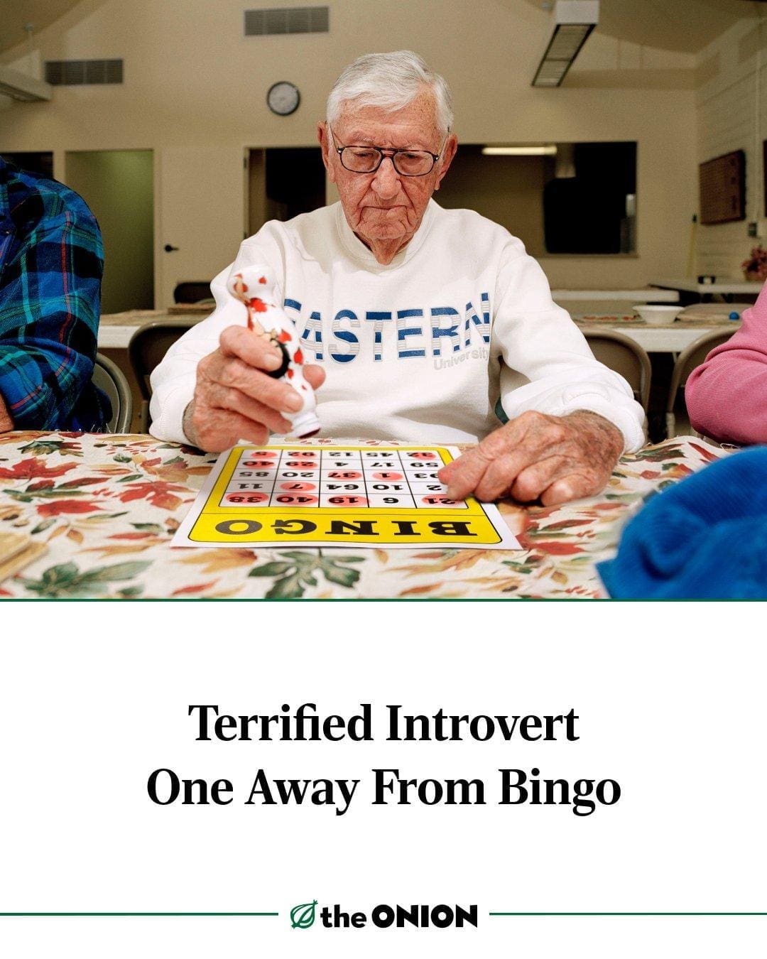 A satirical headline and news photo layout from The Onion features a shot of an intensely focused elderly man with an ink dauber under the title "Terrified Introvert One Away From Bingo," delivering a masterclass in social anxiety humor.