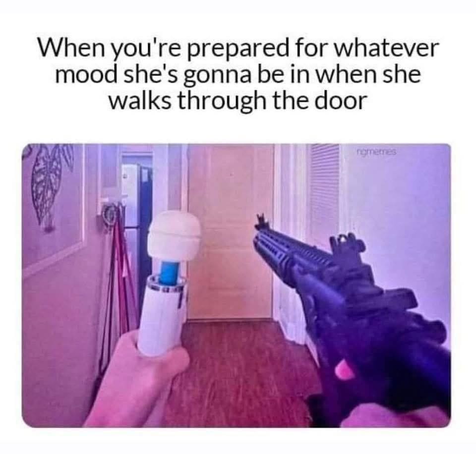 A first-person perspective holding a white Hitachi personal massager in the left hand and an assault rifle in the right hand captures a hilarious classic meme about being prepared for a partner's volatile mood shifts.