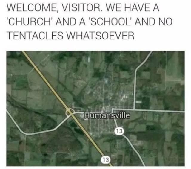 A sci-fi horror parody functions as a classic meme, showing a satellite map view of a real town called "Humansville" under a highly suspicious greeting: "WELCOME, VISITOR. WE HAVE A 'CHURCH' AND A 'SCHOOL' AND NO TENTACLES WHATSOEVER."