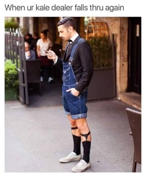 An old memes favorite mocking urban subcultures features a photo of a man in an absurdly formal suit jacket paired with denim shortalls and high socks with garters checking his phone under the caption, "When ur kale dealer falls thru again."