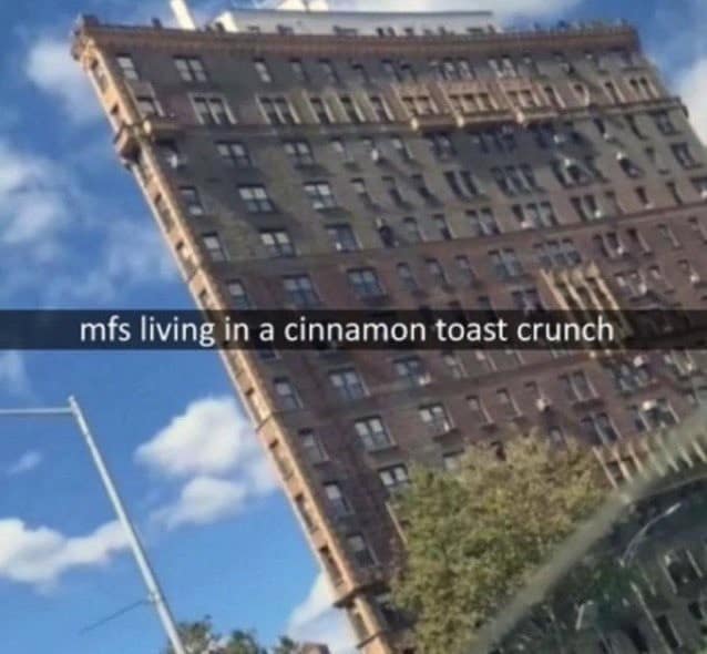 A classic meme featuring a low-angle photo of a remarkably thin, wedge-shaped building, captioned "mfs living in a cinnamon toast crunch."