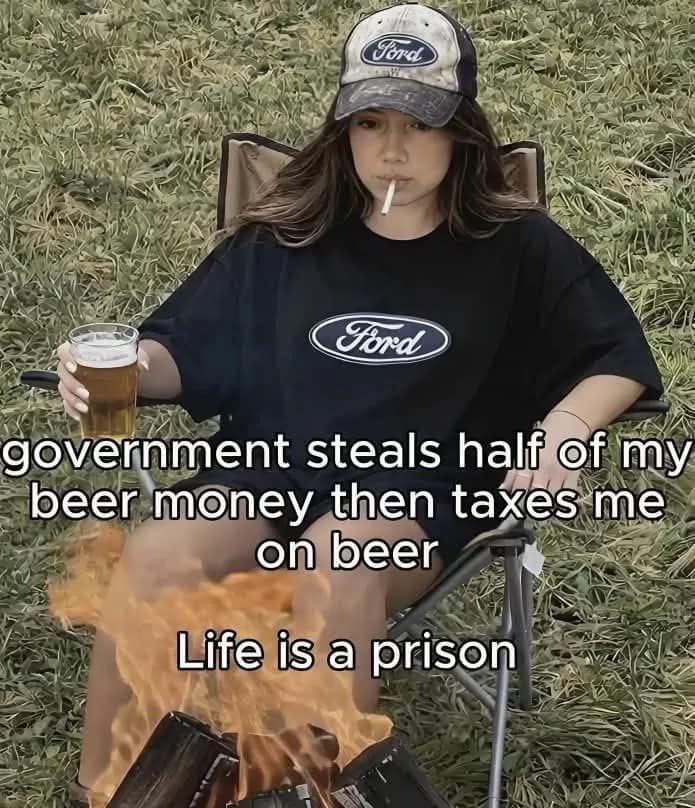A young woman in a Ford hat and shirt sits by a campfire with a beer in this classic meme. Sarcastic text reads: "government steals half of my beer money then taxes me on beer. Life is a prison."