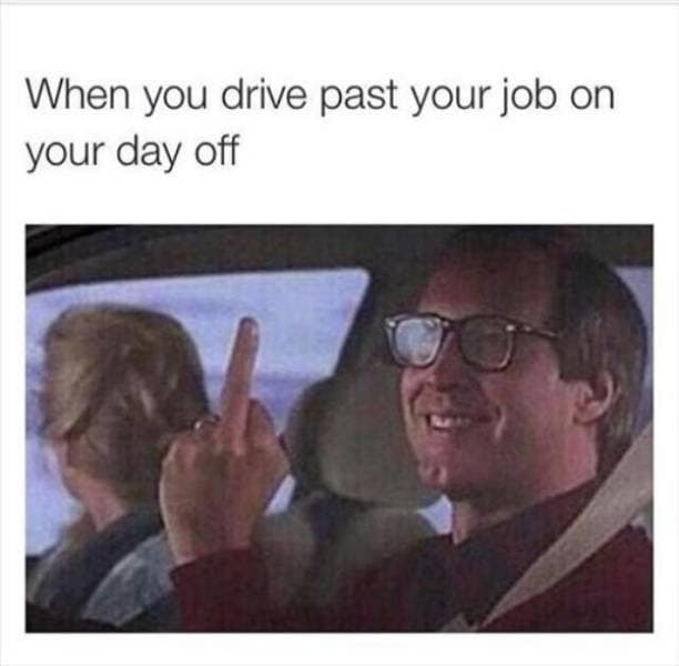 A classic meme of a grinning Chevy Chase in a car holding up a confident middle finger, captioned with the feeling of driving past your place of employment on a day off.