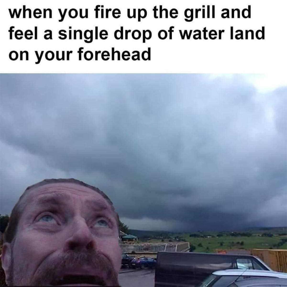 classic meme showing a massive wall of dark rain clouds quickly blanketing the sky above a parking lot, with a close-up photo of a man staring upward with wide eyes of pure panic, captioned about feeling a single drop of water right after firing up the grill.