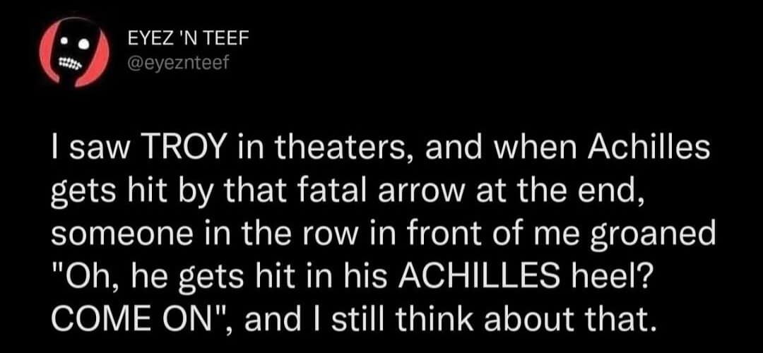 A movie-logic classic meme tweet by "EYEZ 'N TEEF" about seeing the movie TROY and hearing an audience member groan in disbelief when Achilles is hit in the heel.