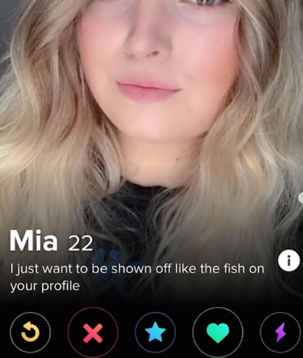 funny dating app profile for 22-year-old Mia displays a close-up shot of her blonde hair and face above a witty bio targeting a classic trend, reading, "I just want to be shown off like the fish on your profile".