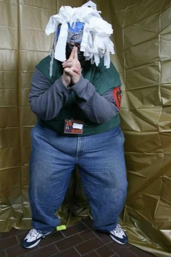 A man performing a cursed cosplay of Kakashi from Naruto, using a massive pile of shredded white toilet paper or tissues as a substitute for ninja hair.