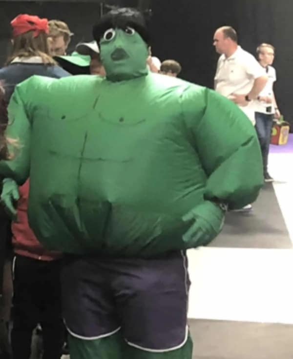 An inflatable green bodysuit used for a cursed cosplay of the Hulk, featuring a tiny, bewildered face peering out from the neck of the massive suit.