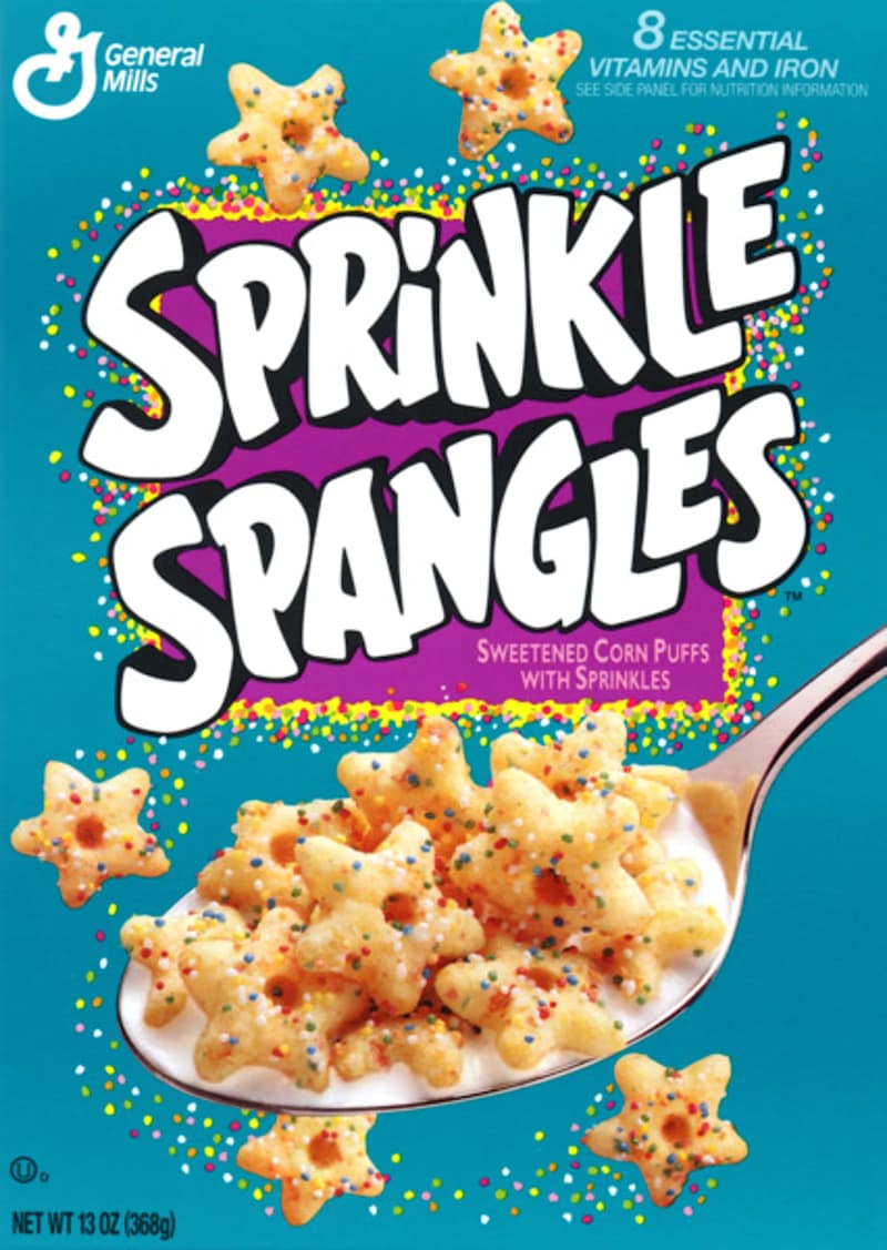 A bright turquoise box of General Mills Sprinkle Spangles star-shaped corn puffs showcases a beloved 90s nostalgic cereal, highlighting a massive spoonful of sprinkle-covered stars.