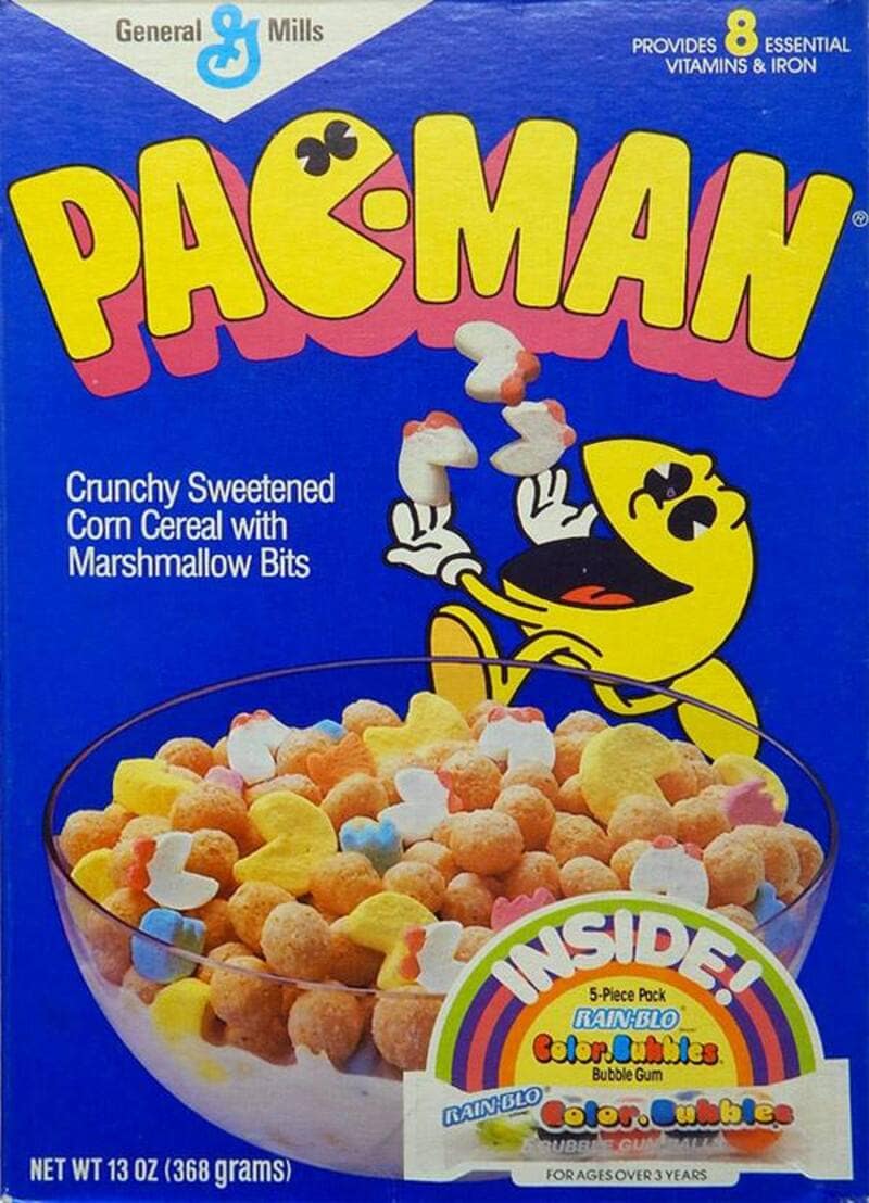 A classic 1980s blue box of General Mills Pac-Man cereal showcases a legendary arcade-themed nostalgic cereal, featuring the yellow Pac-Man character juggling colorful ghost and pellet marshmallows.