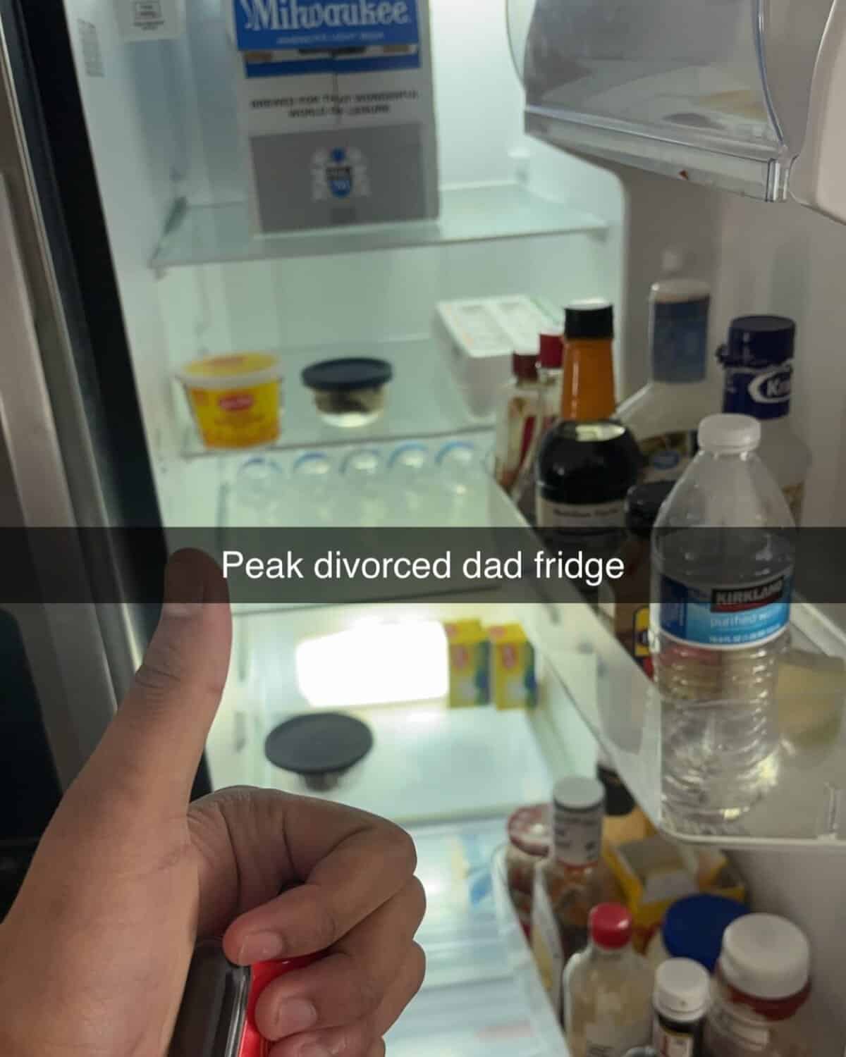 Sparse refrigerator shelves containing mostly condiments, water, and a large Milwaukee beer box.
