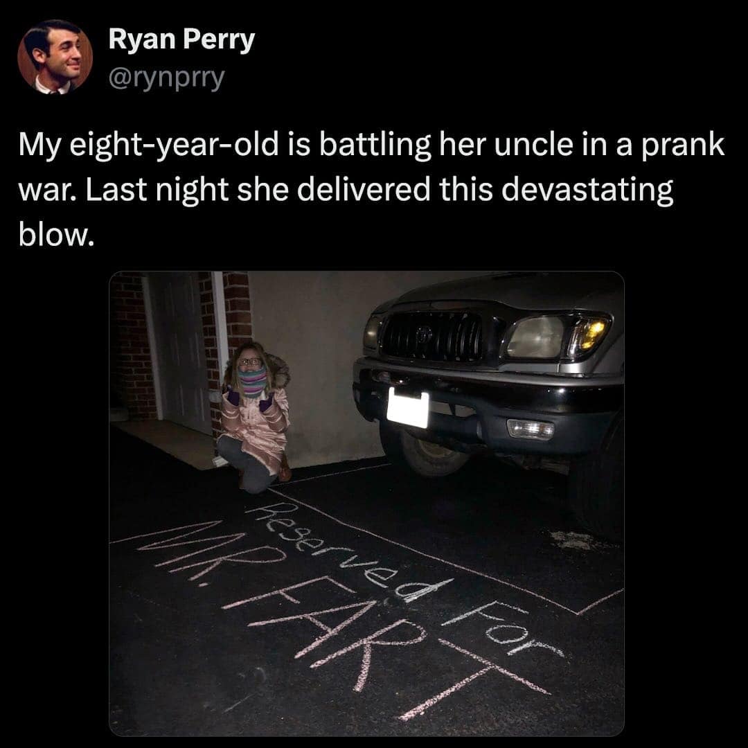 A young girl squats next to a driveway where she has written Reserved For MR. FART in chalk as a part of a prank war, creating a wholesome fart meme.