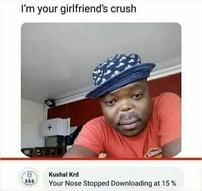 A man in a patterned hat is roasted for his "15% downloaded" nose.
