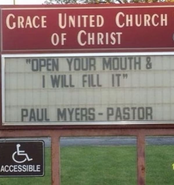 A red and white sign for Grace United Church of Christ featuring a quote about filling open mouths from Pastor Paul Myers, making it a viral funny church sign.
