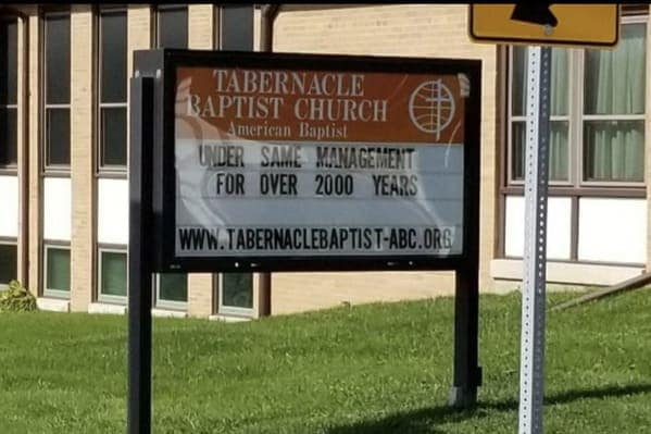Tabernacle Baptist Church sign with a corporate-style quip stating they have been under the same management for over 2000 years, making for a witty funny church sign.