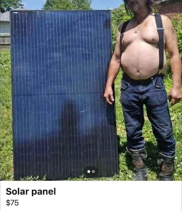 A shirtless man wearing black suspenders, heavy work boots, and blue jeans stands outside in a grassy yard next to a massive rectangular solar panel array in a funny Facebook marketplace ad.
