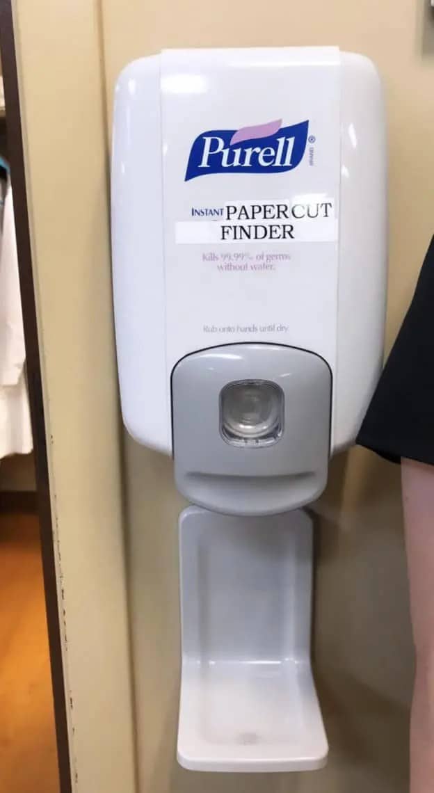 Hand sanitizer dispenser cleverly labeled as an instant papercut finder with a sticker.
