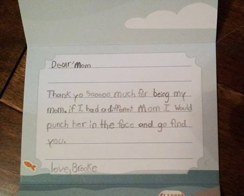 A funny kids note from Brooke to her mom written on stationery with a light blue sky, stating that she loves her so much that if she had a different mom, she would "punch her in the face" and go find her real one.