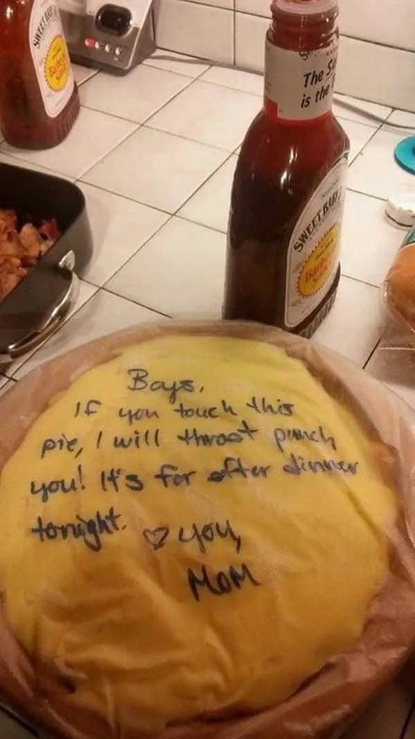 Funny photo of a homemade pie with a warning message from Mom written in the frosting.