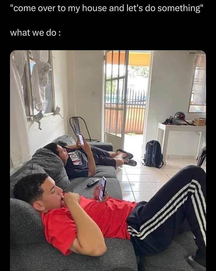 Relatable meme showing two friends lying on a sofa looking at their phones while hanging out.