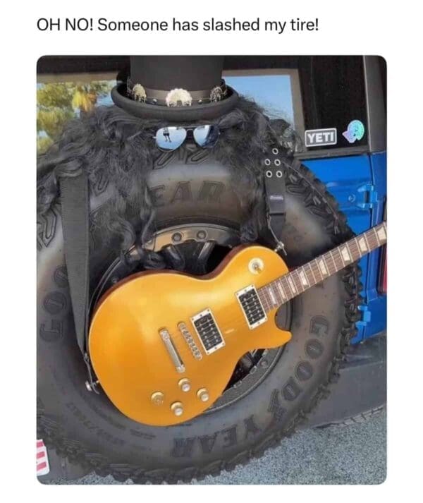A punny meme showing a Jeep's spare tire dressed up as the guitarist Slash with a top hat, wig, sunglasses, and a Gibson Les Paul, captioned "Someone has slashed my tire!"