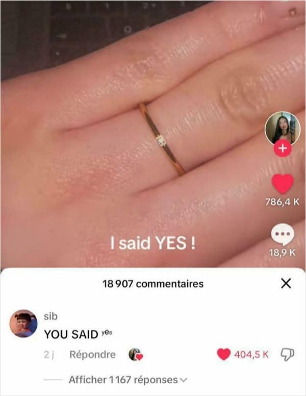 A TikTok video screenshot showing a hand with an incredibly thin, microscopic diamond ring and the text I said YES!. A commenter provides a subtle funny insult by rewriting the phrase with a tiny, lowercase yes to match the ring's diminutive size.