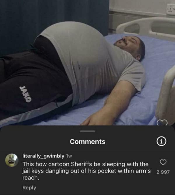 A photo of a man lying in a hospital bed with a very large, perfectly spherical stomach. A comment offers a funny roast comparing his sleeping posture to a cartoon sheriff with jail keys dangling just out of reach.