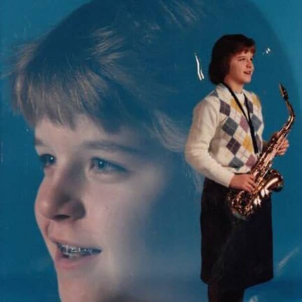 Double exposure portrait of a girl with braces holding a saxophone on blue background.