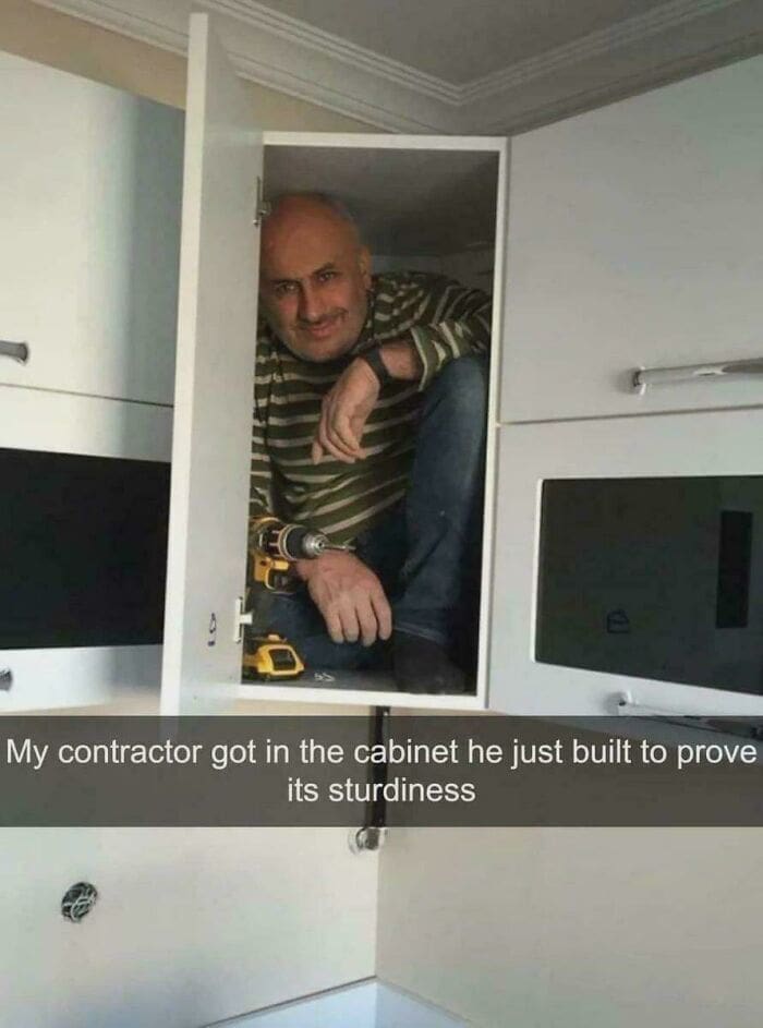 Screenshot of a contractor sitting inside a kitchen cabinet he built to show its strength.