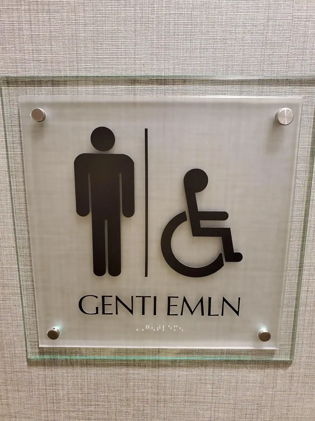 Public restroom sign featuring a hilarious misspelling of the word gentlemen as genti emln.