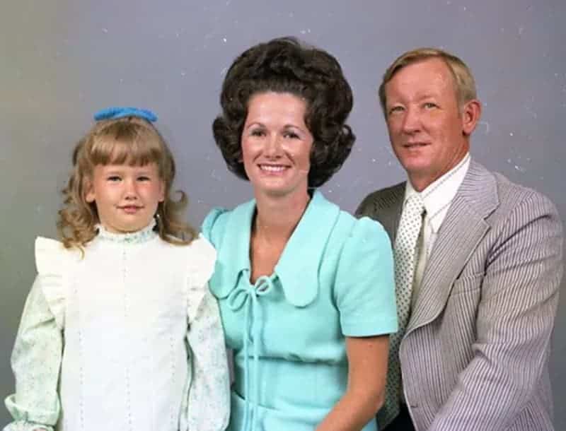 Hilarious vintage portrait with a truly monumental brown beehive hairstyle and patterned dress.