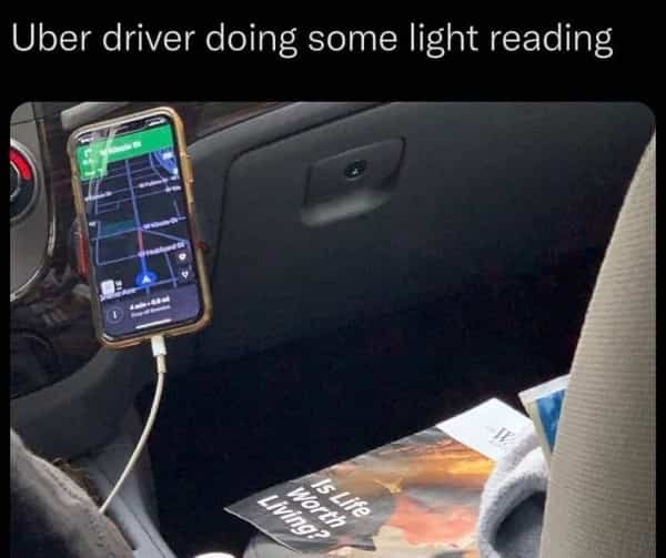 Photo of an Uber driver's dashboard with a magazine titled "Is Life Worth Living?"
