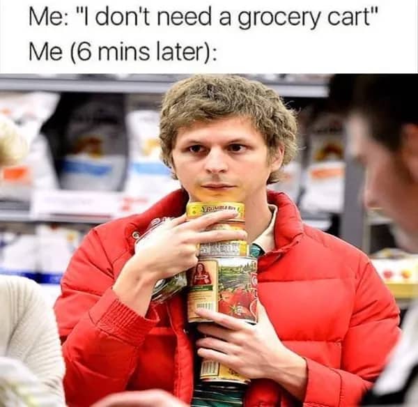 Actor Michael Cera struggling to hold an overload of canned goods without a shopping cart.