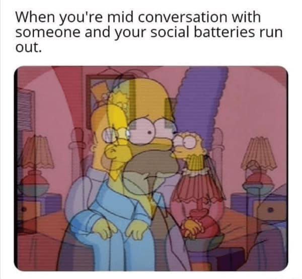 An introvert meme using a blurry, vibrating, multi-layered image of Homer Simpson sitting on a bed. The caption reads: "When you're mid conversation with someone and your social batteries run out," perfectly capturing the feeling of mental dissociation.
