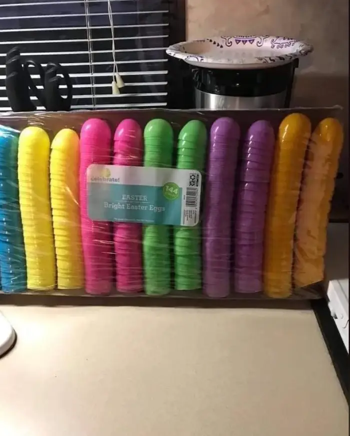 Packed stack of plastic colorful easter egg halves arranged in vertical rows.