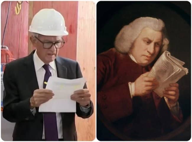 Jerome Powell in a hard hat reading papers next to a portrait of Bach.
