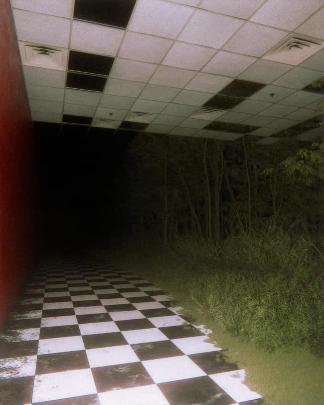 A surreal indoor-outdoor transition zone features a checkered black-and-white tile hallway under a commercial drop ceiling that abruptly blends directly into a dense, pitch-black forest at night.