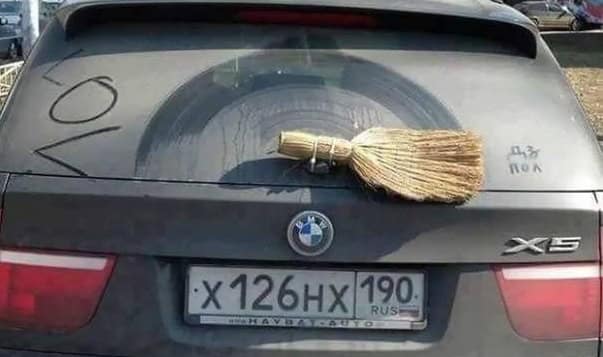 funny Russia picture of a BMW X5 where the owner has strapped a traditional straw hand-broom to the rear wiper blade to clean the window.