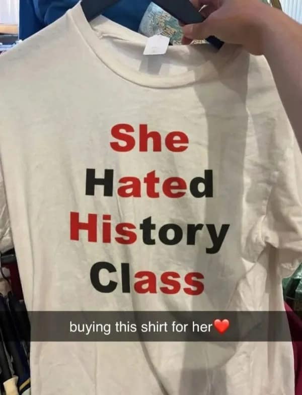 A photo of a white t-shirt that reads "She Hated History Class," where the red-colored letters "S-H-I-T" stand out as a hilarious design fail perfect for a meme dump.