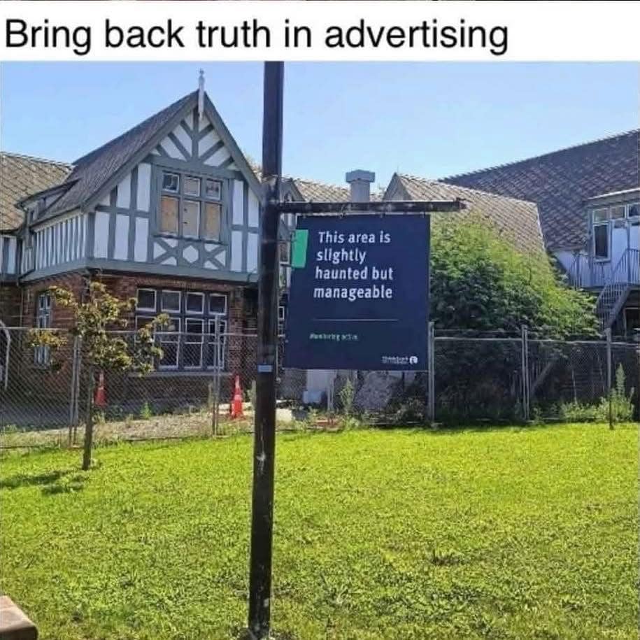 A relatable funny meme showing a dark blue sign posted in a field that reads: "This area is slightly haunted but manageable." The image is captioned with a plea to "Bring back truth in advertising."