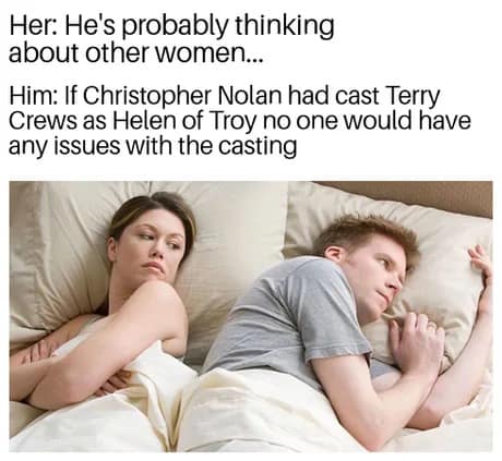 A funny meme using the "he's probably thinking about other women" format, where the man is actually considering how Terry Crews playing Helen of Troy in a Christopher Nolan film would be perfect casting.
