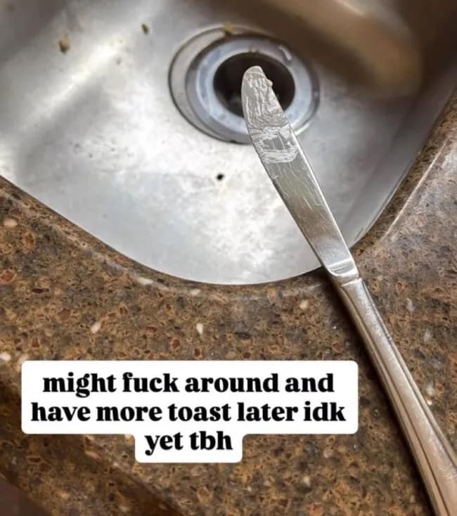 funny meme showing a dirty butter knife resting on a brown granite counter, captioned with the reckless intent to "fuck around and have more toast later."