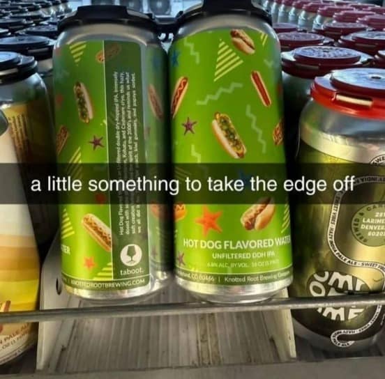 A grocery store refrigerator shelf showcasing bright green cans of craft beer labeled "HOT DOG FLAVORED WATER UNFILTERED DDH IPA" from Knotted Root Brewing Co. beneath a text banner about taking the edge off.
