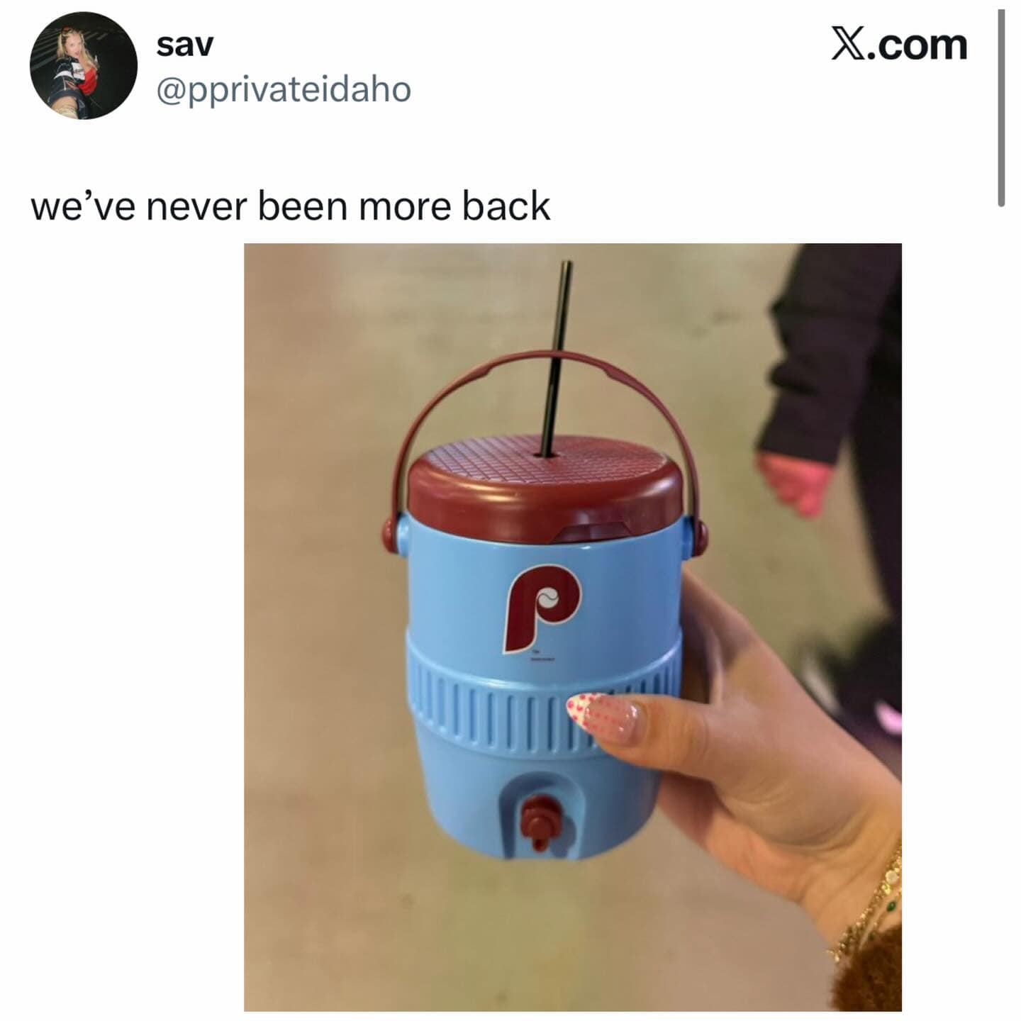 A high-octane celebratory meme dump photo of a Phillies-branded mini water cooler jug fitted with a straw, captioned "we’ve never been more back."