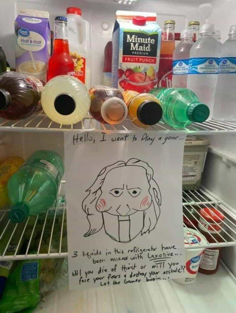 A chaotic "Jigsaw" prank photo showing a note taped to a refrigerator shelf that claims three of the drinks have been spiked with laxatives, challenging the viewer to "face their fears."