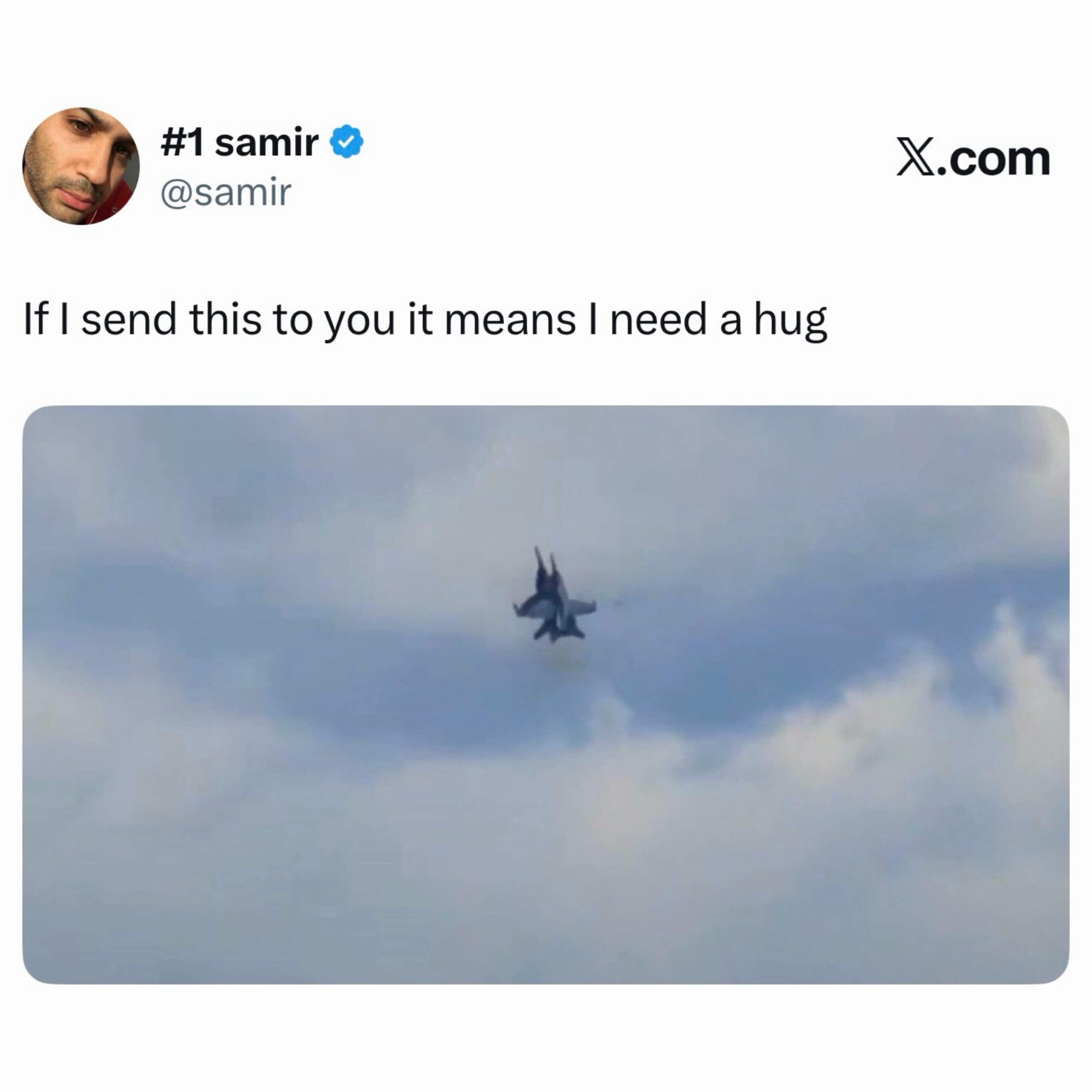 A military fighter jet executing a vertical climb straight through heavy grey storm clouds is featured in a text-based post about a unique code for needing a hug.