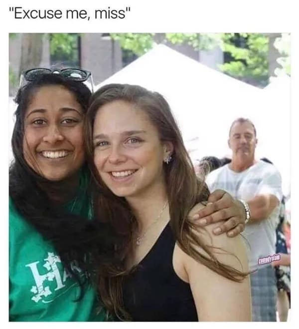 A funny photobomb meme dump photo where a man with a blank, intense stare peeks between two smiling women taking a selfie, captioned with the intrusive phrase "Excuse me, miss."