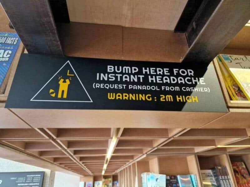 Warning sign on a low beam reading bump here for instant headache request Panadol from cashier.