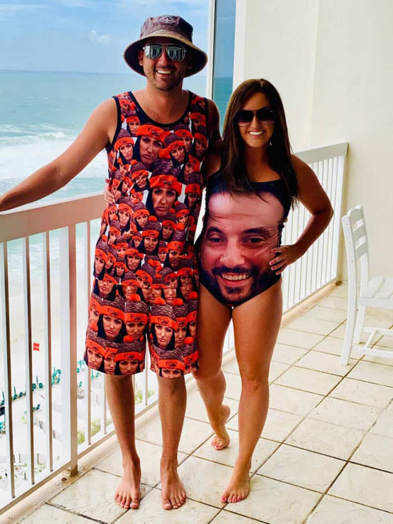 Smiling couple on a balcony wearing matching swimwear custom printed with each other's faces.
